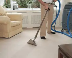 Carpet cleaning professional removing dirt and stains with a hot-water extraction tool in a home, Omaha, NE.