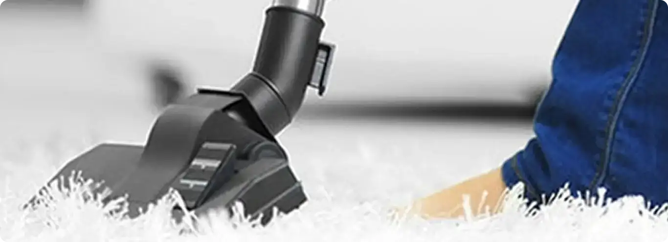 Close-up of a professional vacuuming a white carpet in Bellevue.